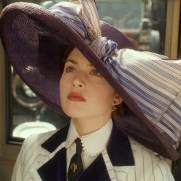 Kate Winslet poartă o pălărie mov cu o fundă mare într-o scenă din Titanic