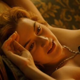 Kate Winslet stă înntinsă pe canapea cu brațul lângă cap
