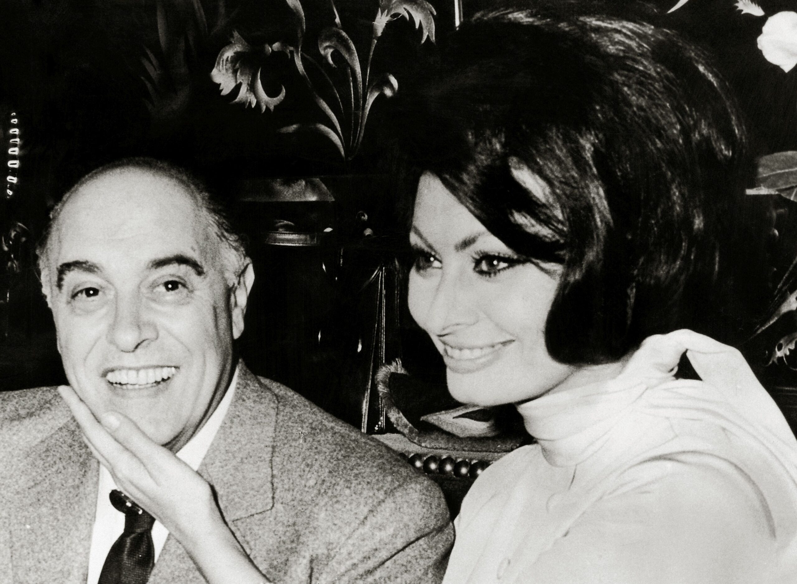 Fotografie alb-negru cu Sophia Loren care îl mângâie pe față pe soțul ei Carlo Ponti
