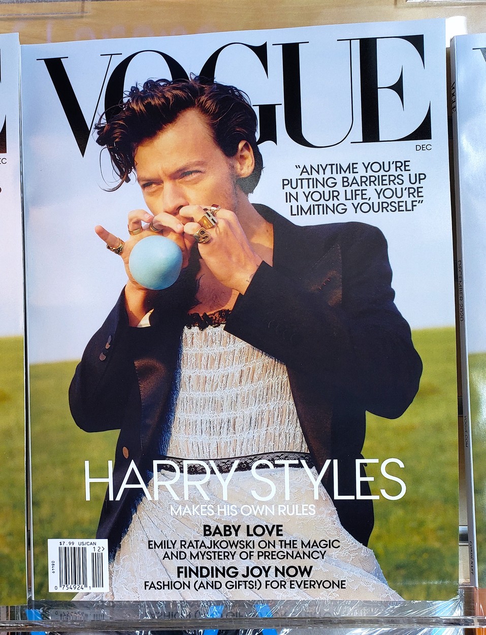 Harry Style pe coperta revistei Vogue sufă într-un balon albastru. Este îmrăcat într-o rochie albă și un blazer Negru