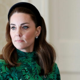Kate Middleton îmrăcată într-o rochie verde, porată o coroniță neagră pe cap și este fardată cu machiaj negru