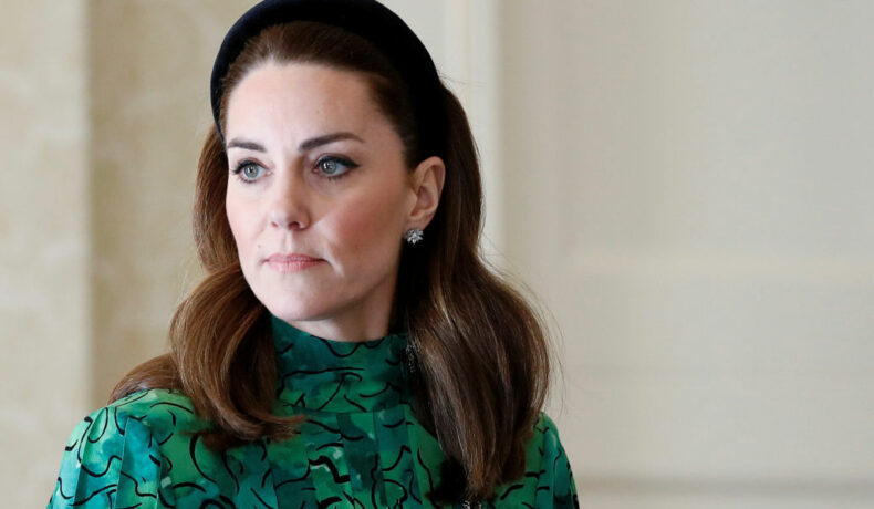Kate Middleton îmrăcată într-o rochie verde, porată o coroniță neagră pe cap și este fardată cu machiaj negru