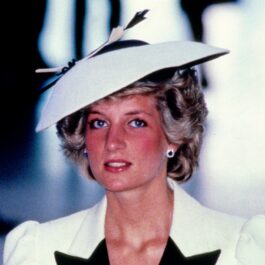 Diana poartă o pălărie albă cu bor rotund și un sacou alb cu aplicații negre
