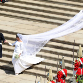 Meghan Markle în rochie de mireasă coboară scările la brațul prințului Harry