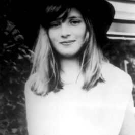 Prințesa Diana într-o imagine alb negru din 1970, când era adolescentă, în timp ce zâmbește la cameră și poartă o ălărie mare neagră