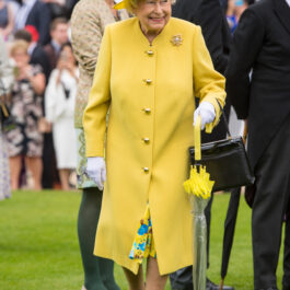 Regina Elisabeta la un eveniment public, îmbrăcată într-o ținută elegantă, galbenă