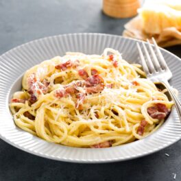 Spaghete carbonara, pe o farfurie albă, gata de sevit
