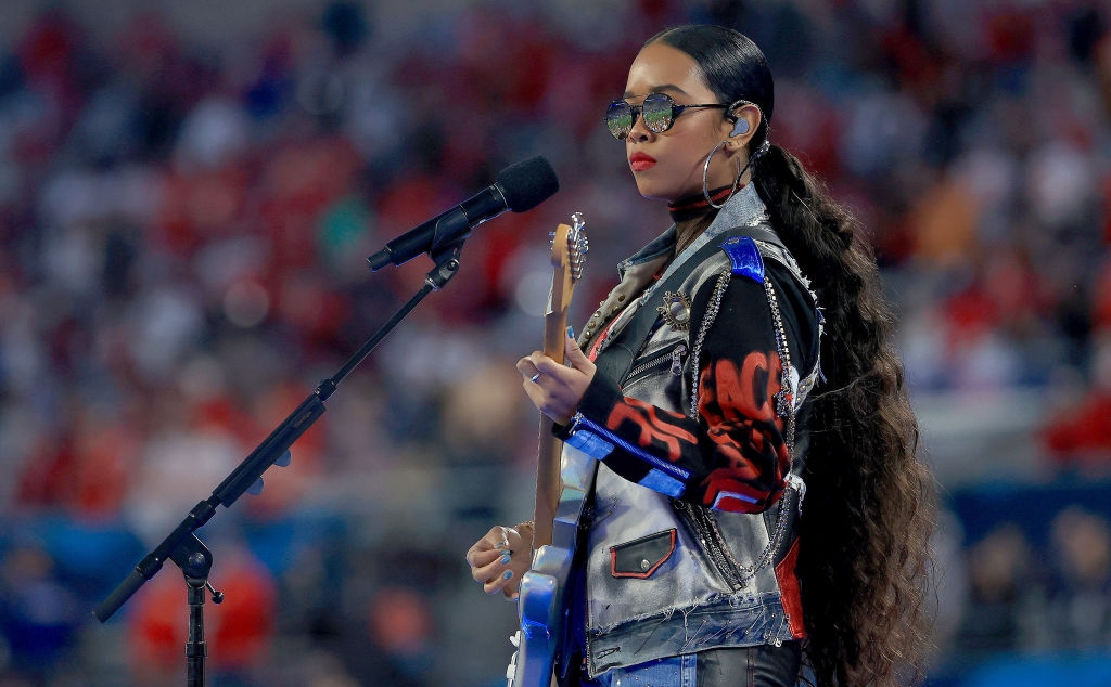 H.E.R. cântă la microfon și la chitara electrică pe scenă la Super Bowl