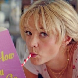Carey Mulligan bea un milkshaik cu un pai roșu și alb în Promising Young Woman