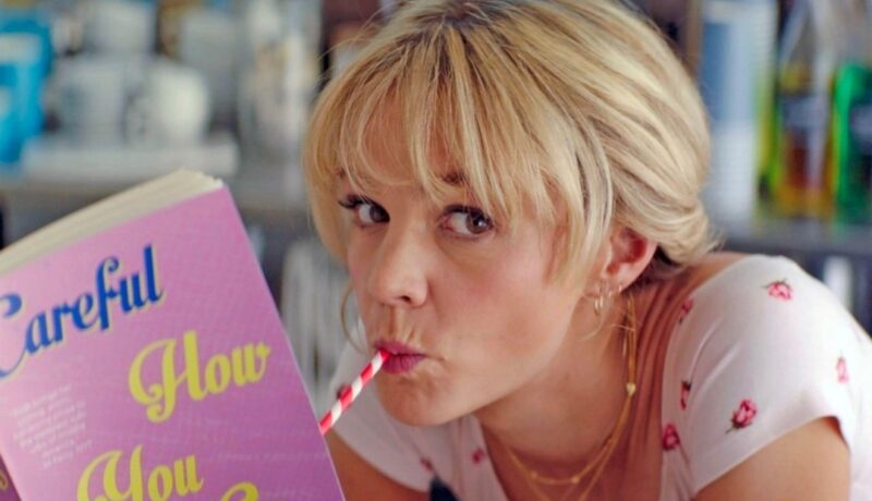 Carey Mulligan bea un milkshaik cu un pai roșu și alb în Promising Young Woman