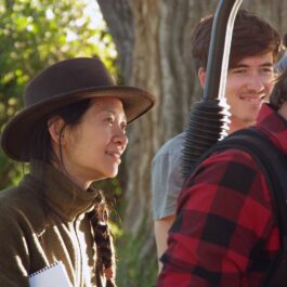 Chloe Zhao poartă o pălărie maro în spatele camerelor în timpul filmărilor pentru The Rider