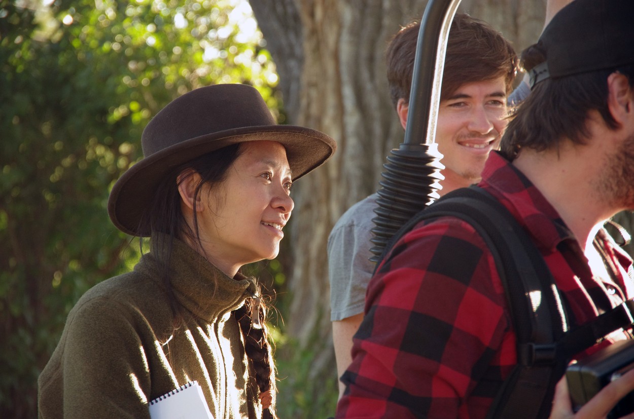 Chloe Zhao poartă o pălărie maro în spatele camerelor în timpul filmărilor pentru The Rider