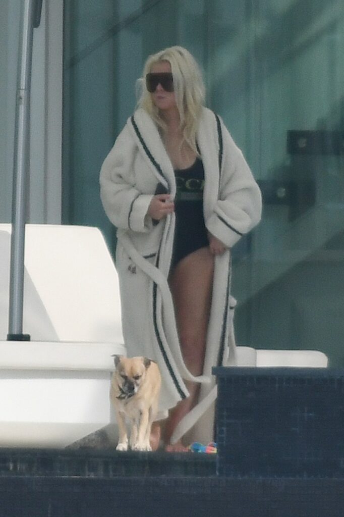 Christina Aguilera, imagine într-un costum de baie negru, întreg, peste care a asortat un halat alb, imens