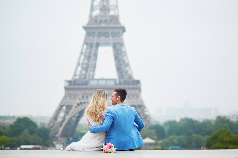 Un tânăr și iubita lui, la Turnul Eiffel din Paris, ne arată cum se sărbătorește Valentine's Day în lume
