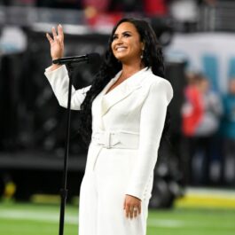 Demi Lovato în timp ce își salută publicul la Super Bowl 2021, îmbrăcată într-o ținută albă