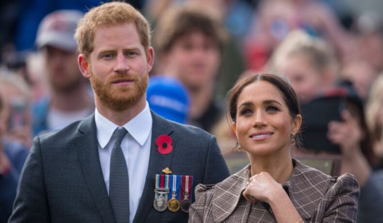 Meghan Markle îmbrăcată într-un palton maro la un eveniment alături de Prințul Harry