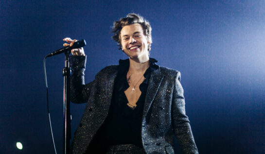 Harry Styles într-un costum sclipitor cântând pe scenă