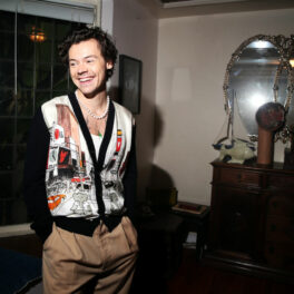 Harry Styles, îmbrăcat într-o ținută lejeră, cu un o bluză cu imprimeuri și pantaloni bej