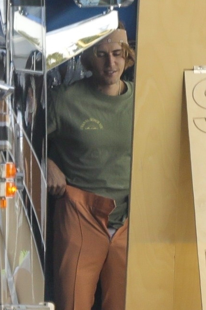 Justin Bieber, fotografiat în timp ce se îmbracă cu o pereche de pantaloni bej