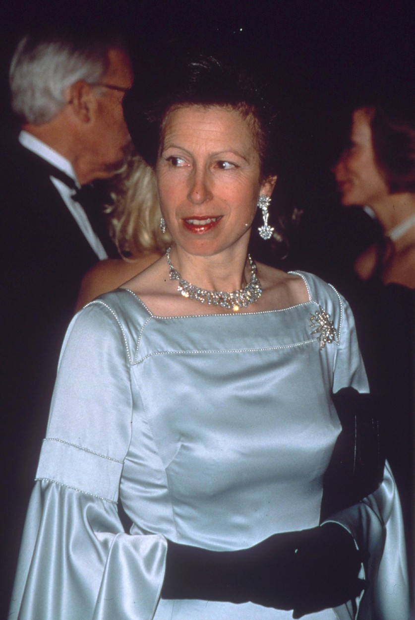 Prințesa Anne la un eveniment îmbrăcată cu o rochie azul din satin și cu mănuși negre