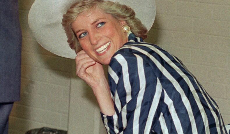 Prințesa Diana zâmbind larg cu o pălăria albă pe cap și cu într-o rochie în dungi albastre