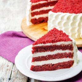 Secțiune dintr-un Red Velvet Cake pe un platou alb, gata de a fi servită de ziua îndrăgostiților
