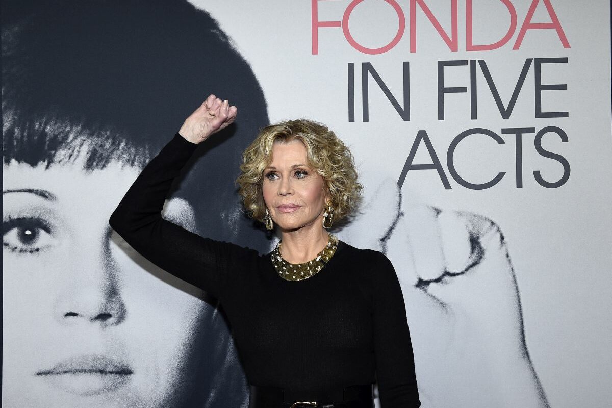 Jane Fonda, într-o rochie neagră, pozează cu pumnul ridicat