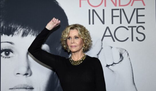 Jane Fonda, într-o rochie neagră, pozează cu pumnul ridicat