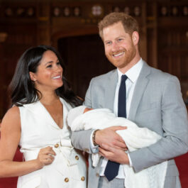 Prințul Harry și Meghan Markle zâmbesc în timp ce îl țin în brațe pe nou-născutul Archie