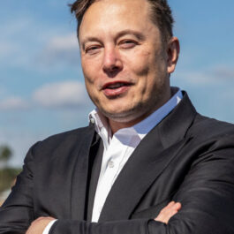 Portret cu Elon Musk îmbrăcat cu un costum negru