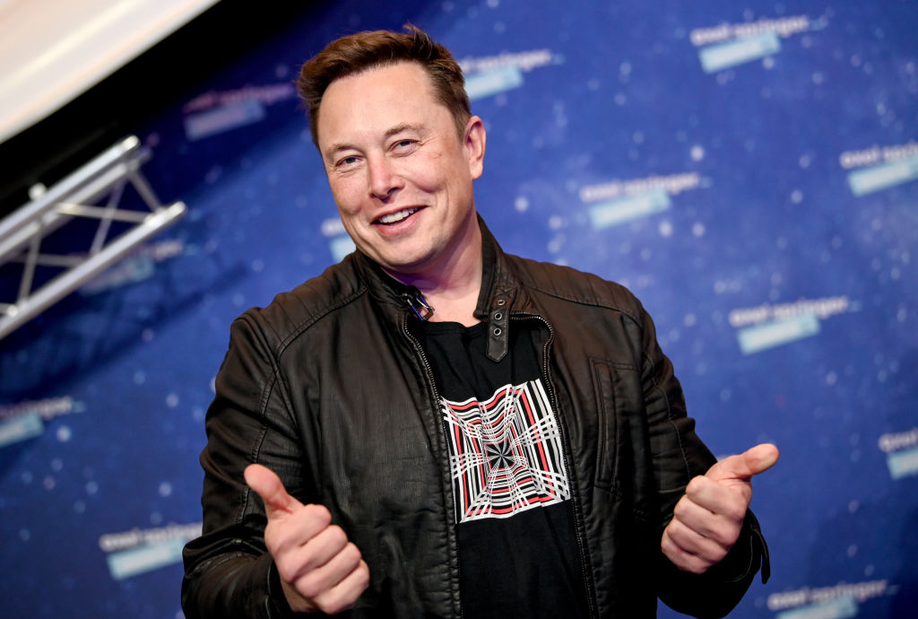 Elon Musk face semnul like cu ambele mâini în timp ce este fotografiat