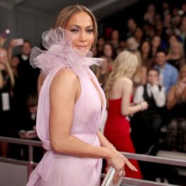 Jennifer Lopez pe covorul roșu îmbrăcată cu o rochie roz pal cu decolteu adânc și fără mâneci