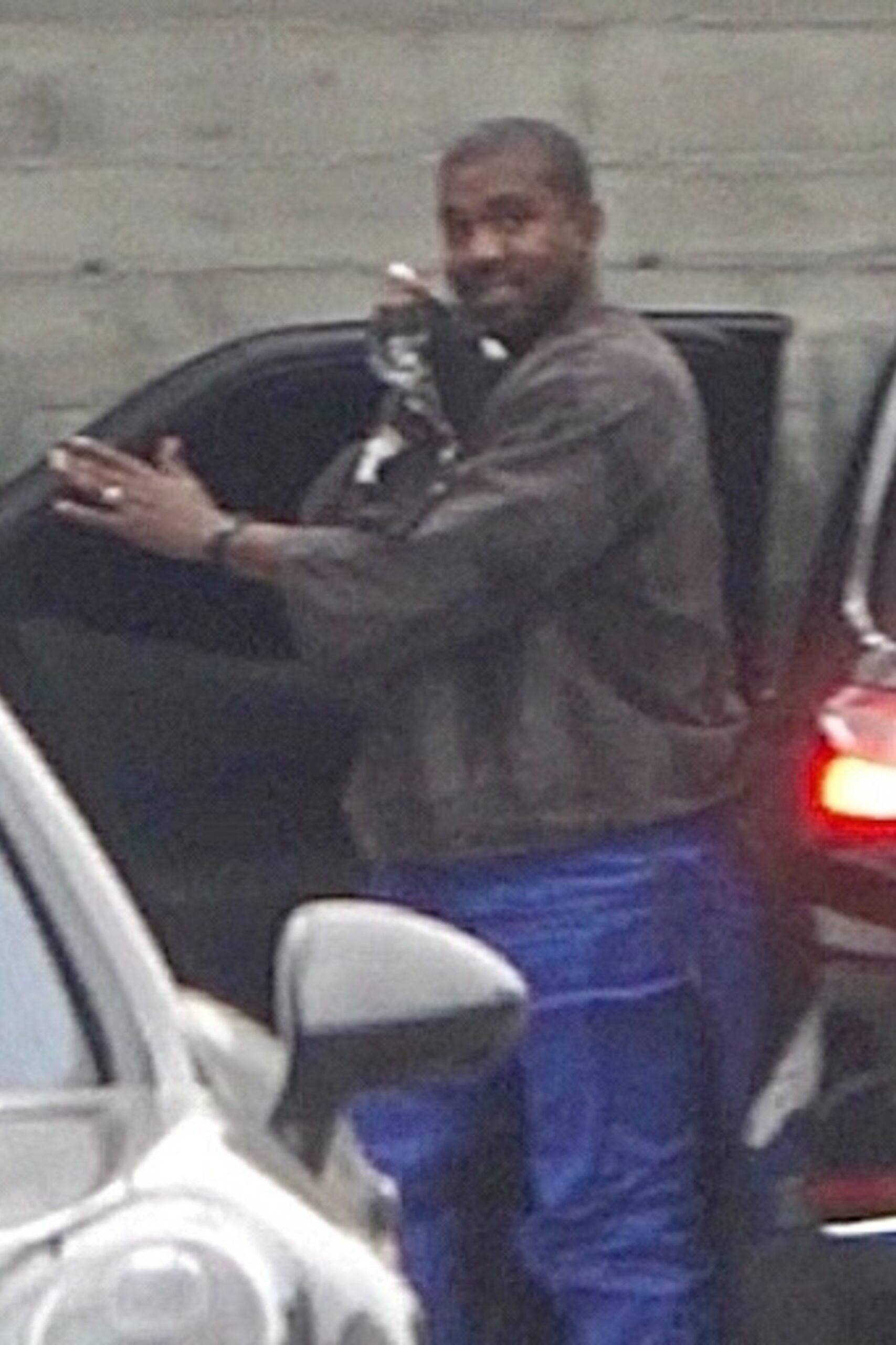 Kanye West, fotografiat de paparazzi în parcare, în timp ce zâmbește la cameră