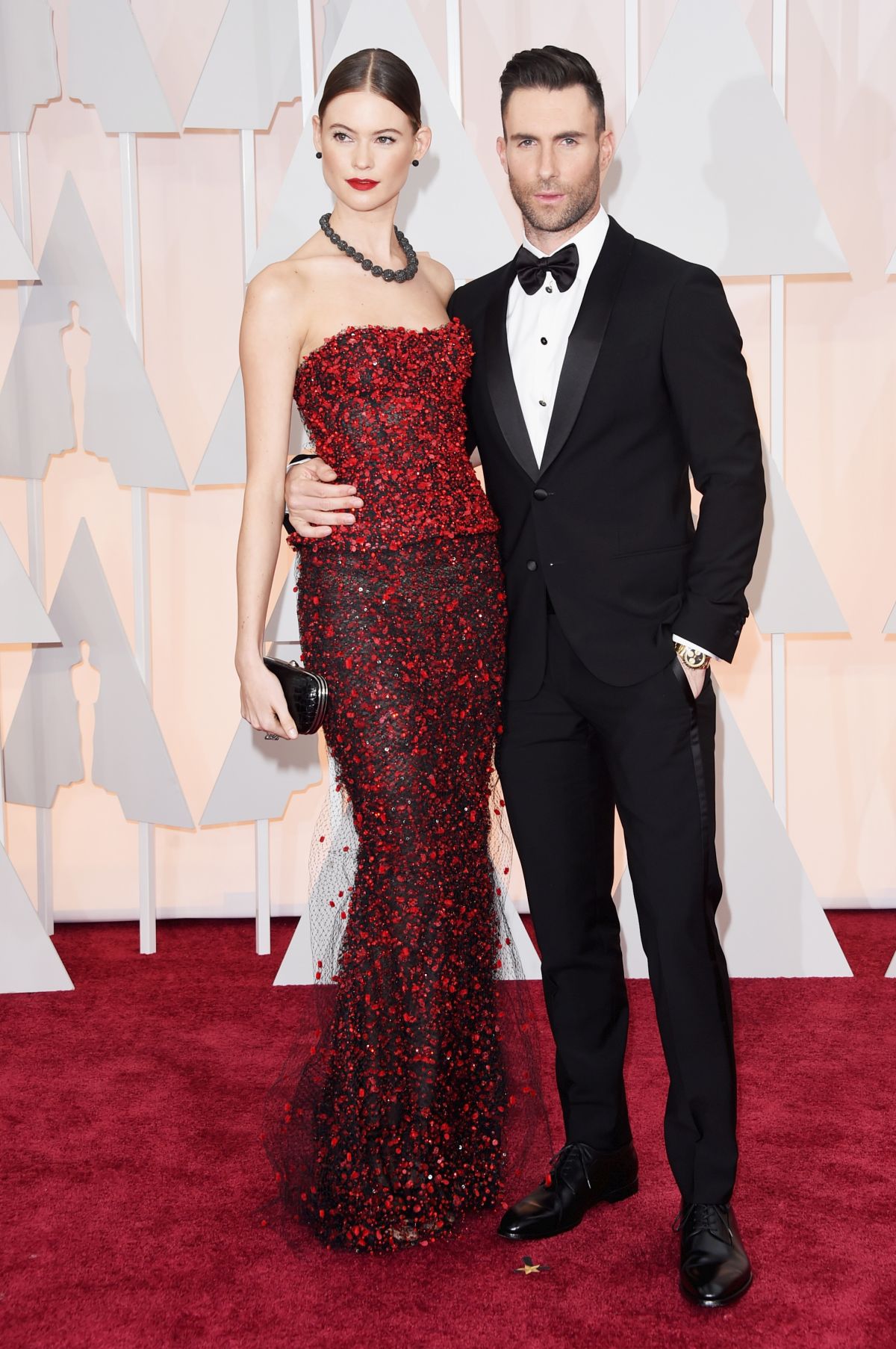 Adam Levine, în costum de culoare neagră, și soția sa, într-o rochie de gală