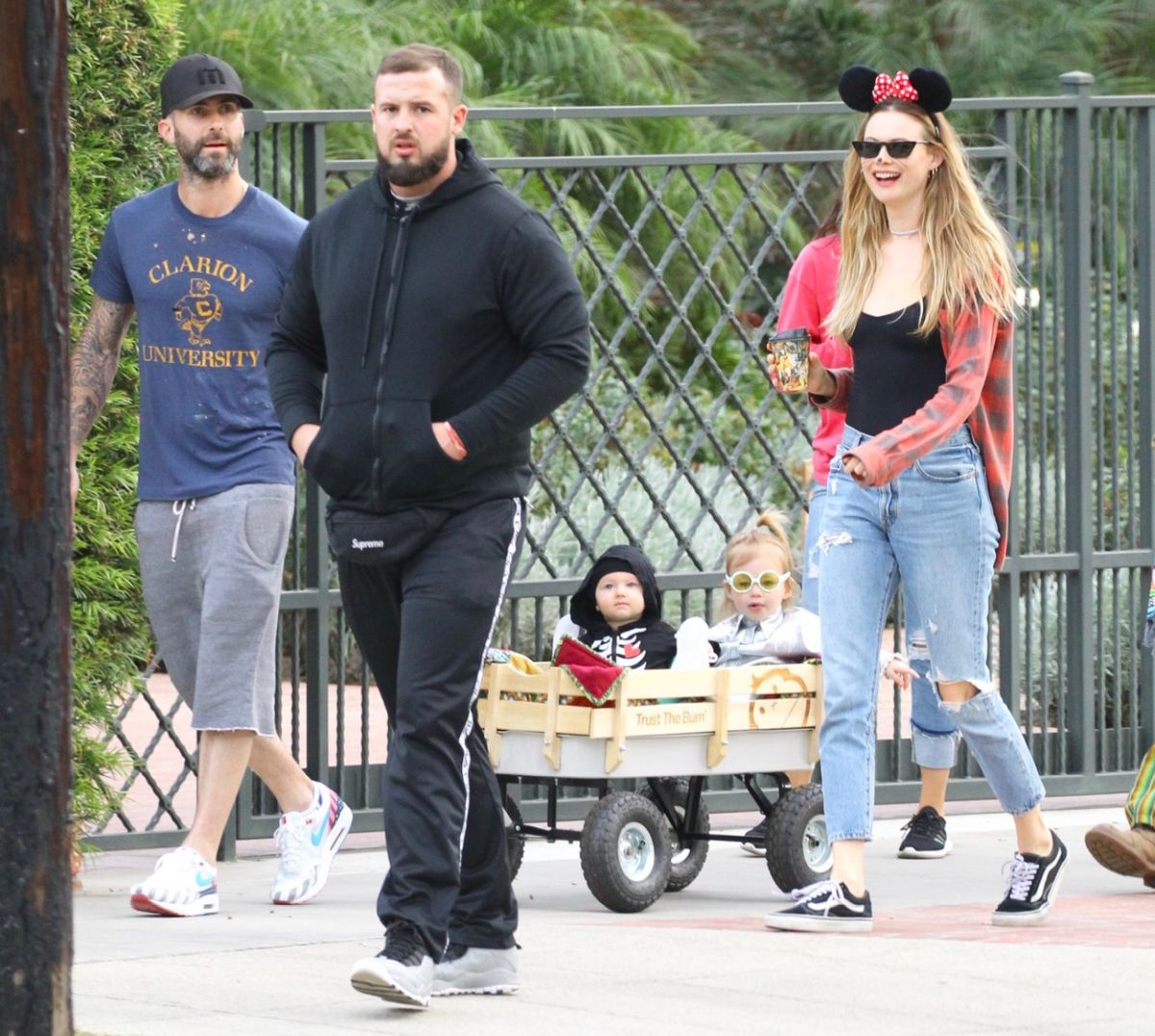 Adam Levine, într-o ținută lejeră, alături de Bhati Prinsloo, ce poartă urechi de Minnie Mouse, și cele două fete ale lor, într-o mică remorcă, cu ocazia Halloween-ului