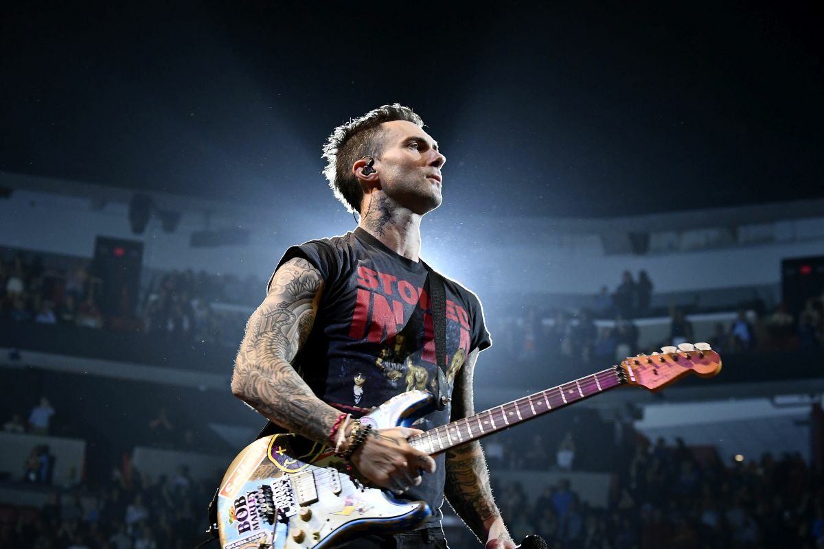 Adam Levine, solistul trupei Maroon5, cu chitara în mână, la unul dintre concertele sale