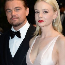 Carey Mulligan, îmbrăcată într-o rochie albă de satin, alături de Leonardo DiCaprio.