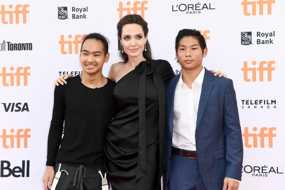 Angelina Joie, îmbrăcată într-o rochie de culoare neagră, se fotografiază alăturid e doi dintre fii săi