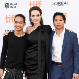 Angelina Joie, îmbrăcată într-o rochie de culoare neagră, se fotografiază alăturid e doi dintre fii săi