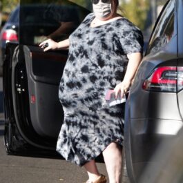 Chrissy Metz, îmbrăcată într-o rochie lejeră de culoare gri cu negru, coborând dintr-o mașină
