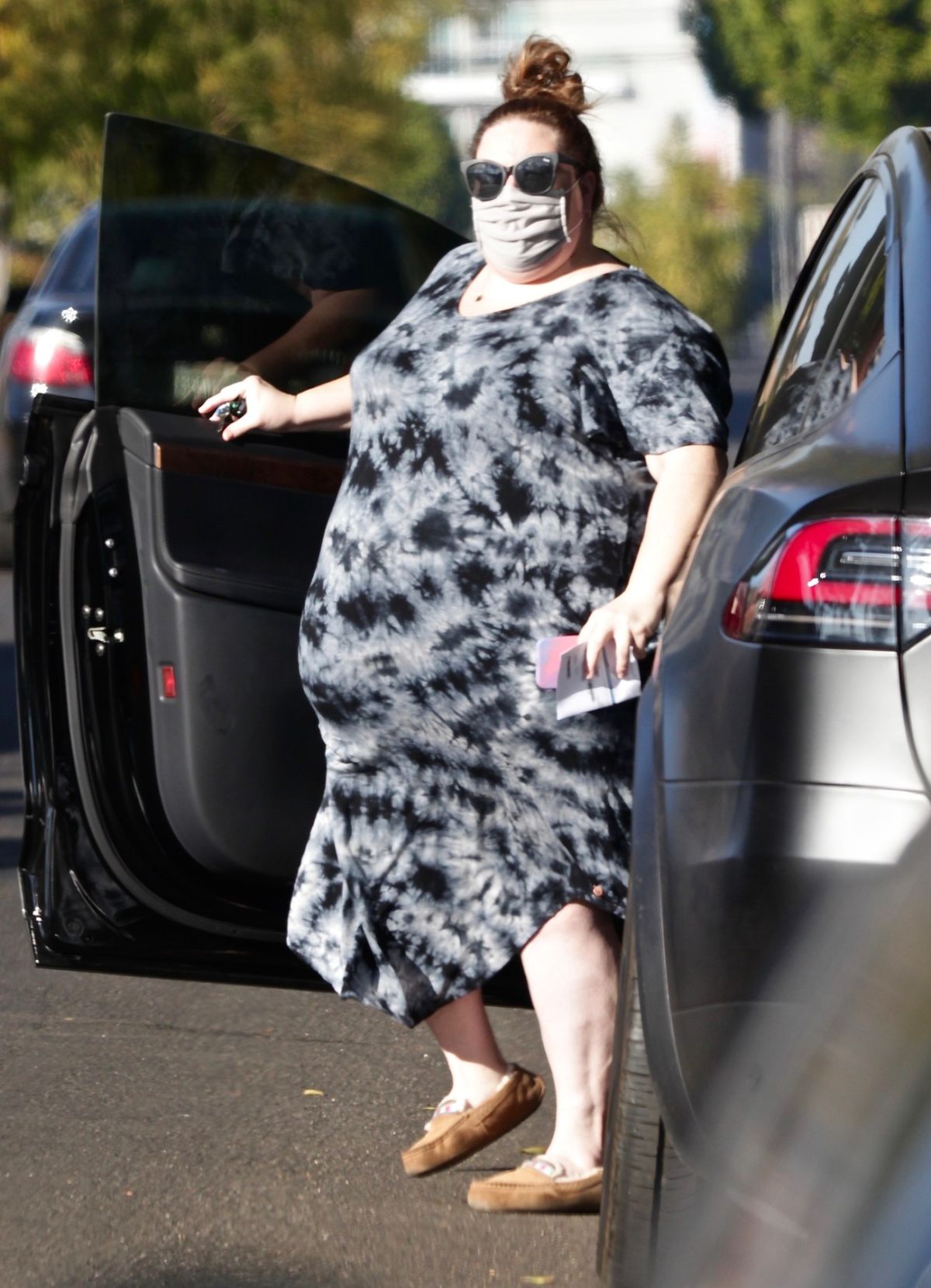 Chrissy Metz, îmbrăcată într-o rochie lejeră de culoare gri cu negru, coborând dintr-o mașină