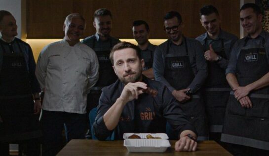 Dani Oțil, la masă, cu mai mulți bucătari în spatele lui