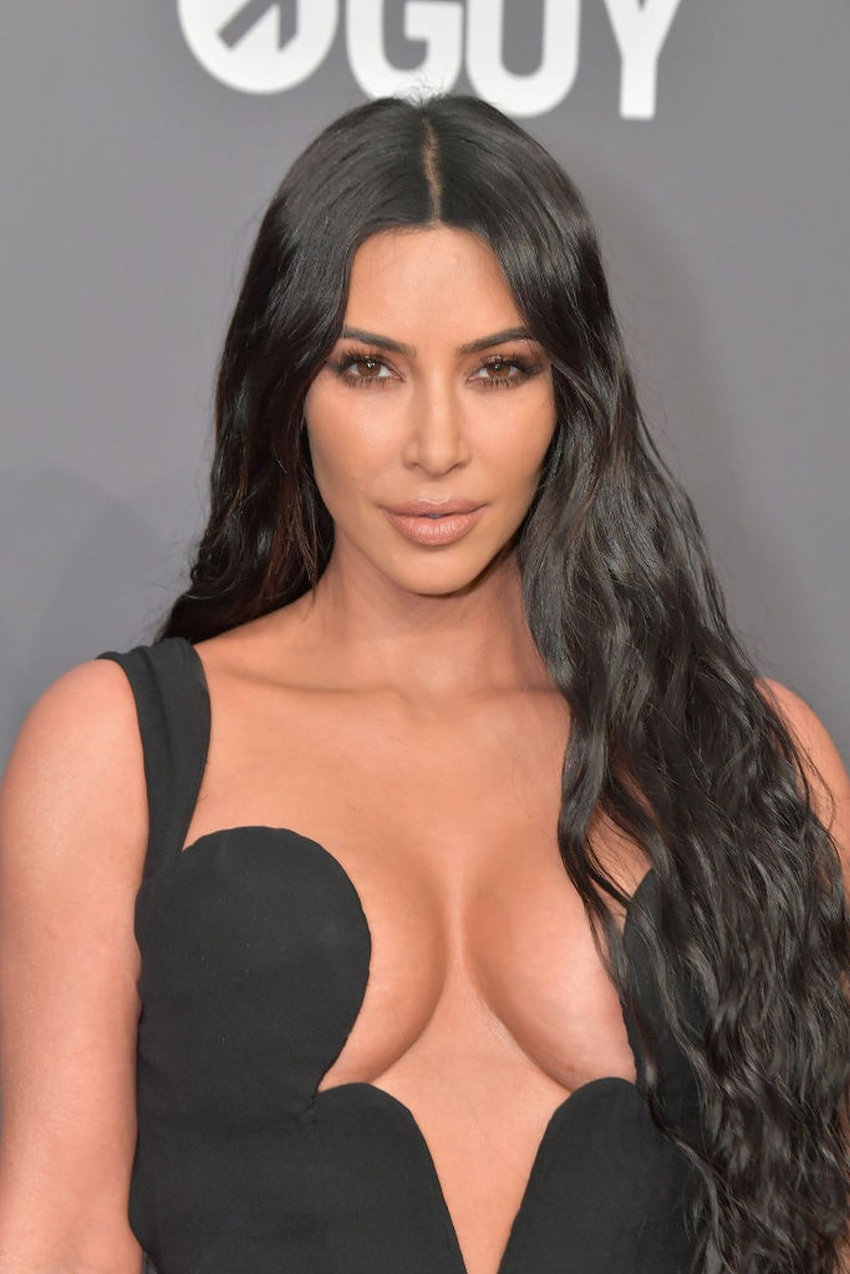 Kim Kardashian, purtând o rochie neagră, decoltată, în cadrul unui eveniment monden