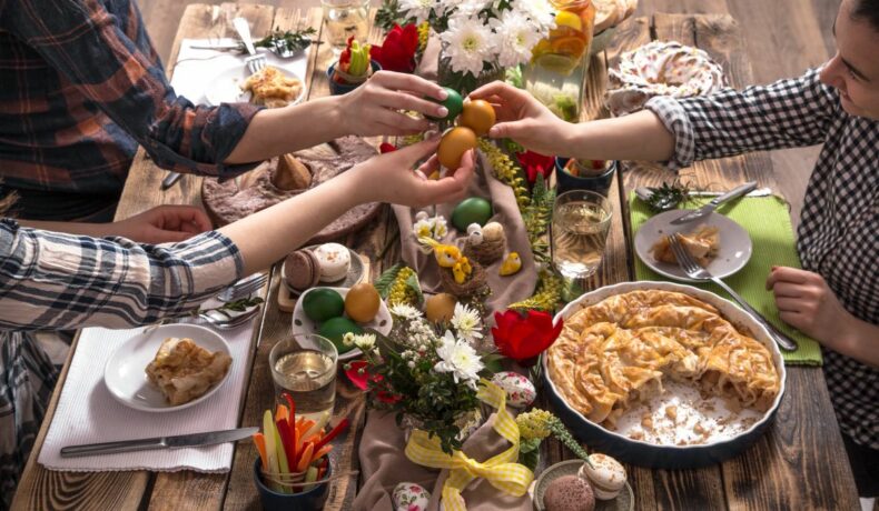 Familia și prietenii, la masa festivă de Paște, ciocnind ouă colorate