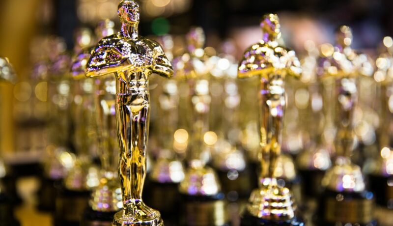O serie de statuete aurii de Oscar, aliniate una lânga alta