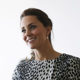 Alegerea vestimentară a lui Kate Middleton în acest portret este o bluză albă cu buline negre și o pereche superbă de cercei perle
