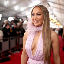Jennifer Lopez, într-o rochie roz, cu volane, pe covorul roșu, la Premiile Grammy