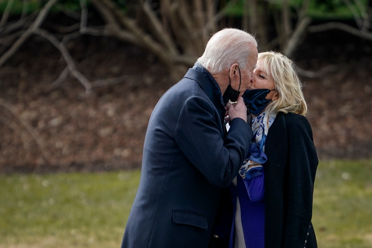 Jill Biden, alături de Joe Biden. Amândoi au măști albastru închis și poartă paltoane de aceeași culoare.
