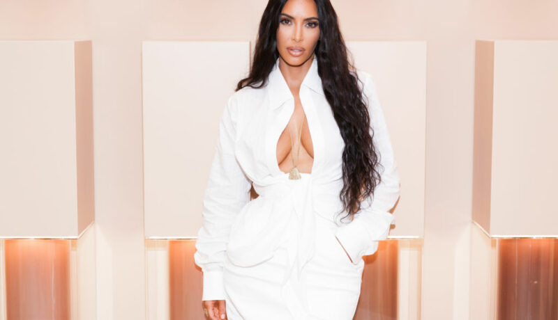 Kim Kardashian, la deschiderea unui magazin cu produse realizate de ea, îmbrăcată într-o rochie albă, cu decolteu adânc