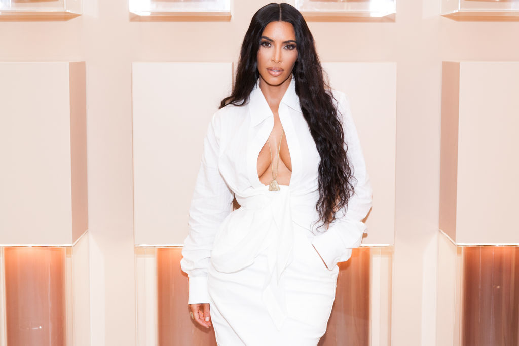Kim Kardashian, la deschiderea unui magazin cu produse realizate de ea, îmbrăcată într-o rochie albă, cu decolteu adânc